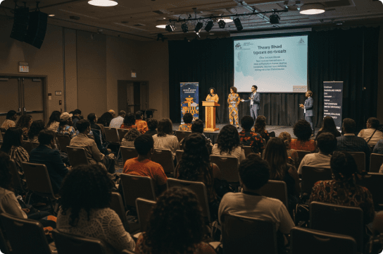 An image of a group of people listening to a TED talk